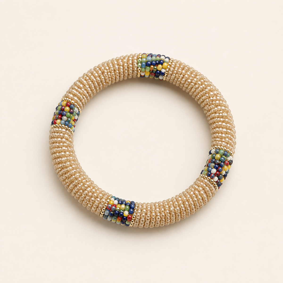 Cream circular beaded bangle with multicoloured accents.