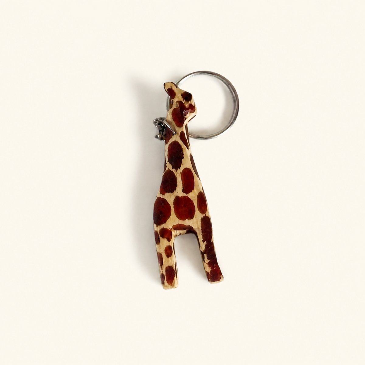 Hand-painted wooden giraffe keyring with a spotted pattern and metal split ring.