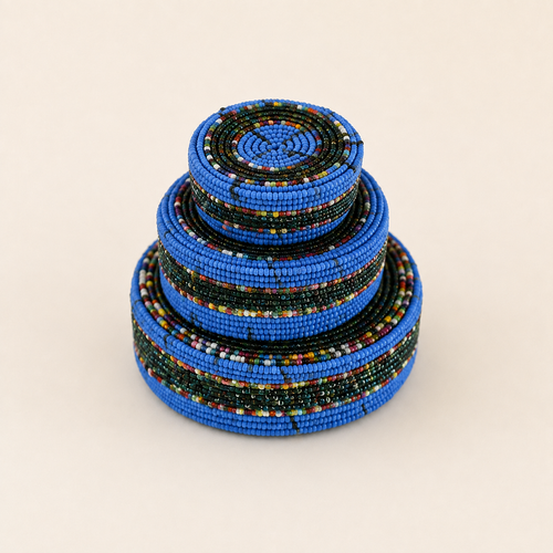 Set of three blue hand-beaded nesting baskets in graduated sizes.