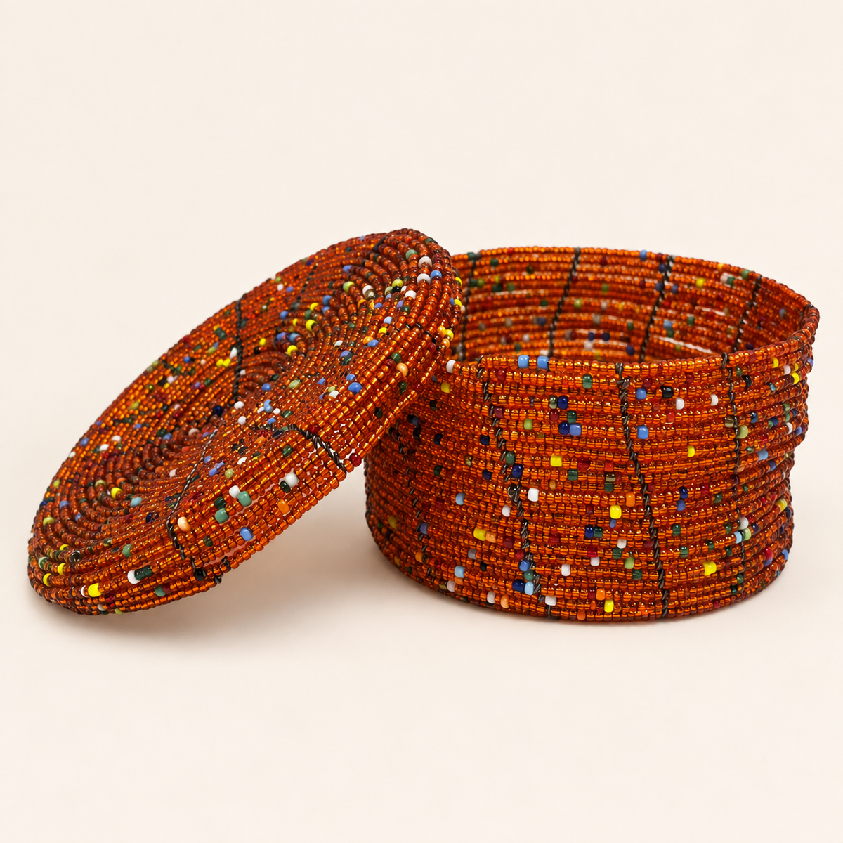 Burnt orange hand-beaded storage box with multicoloured geometric accents and an open lid.