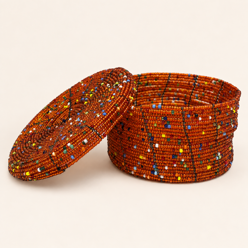 Burnt orange hand-beaded storage box with multicoloured geometric accents and an open lid.